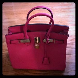 Hot pink, leather, handbag with gold trim.